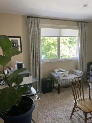Original photograph of the existing window area with curtains, carpet, a houseplant and storage furniture
