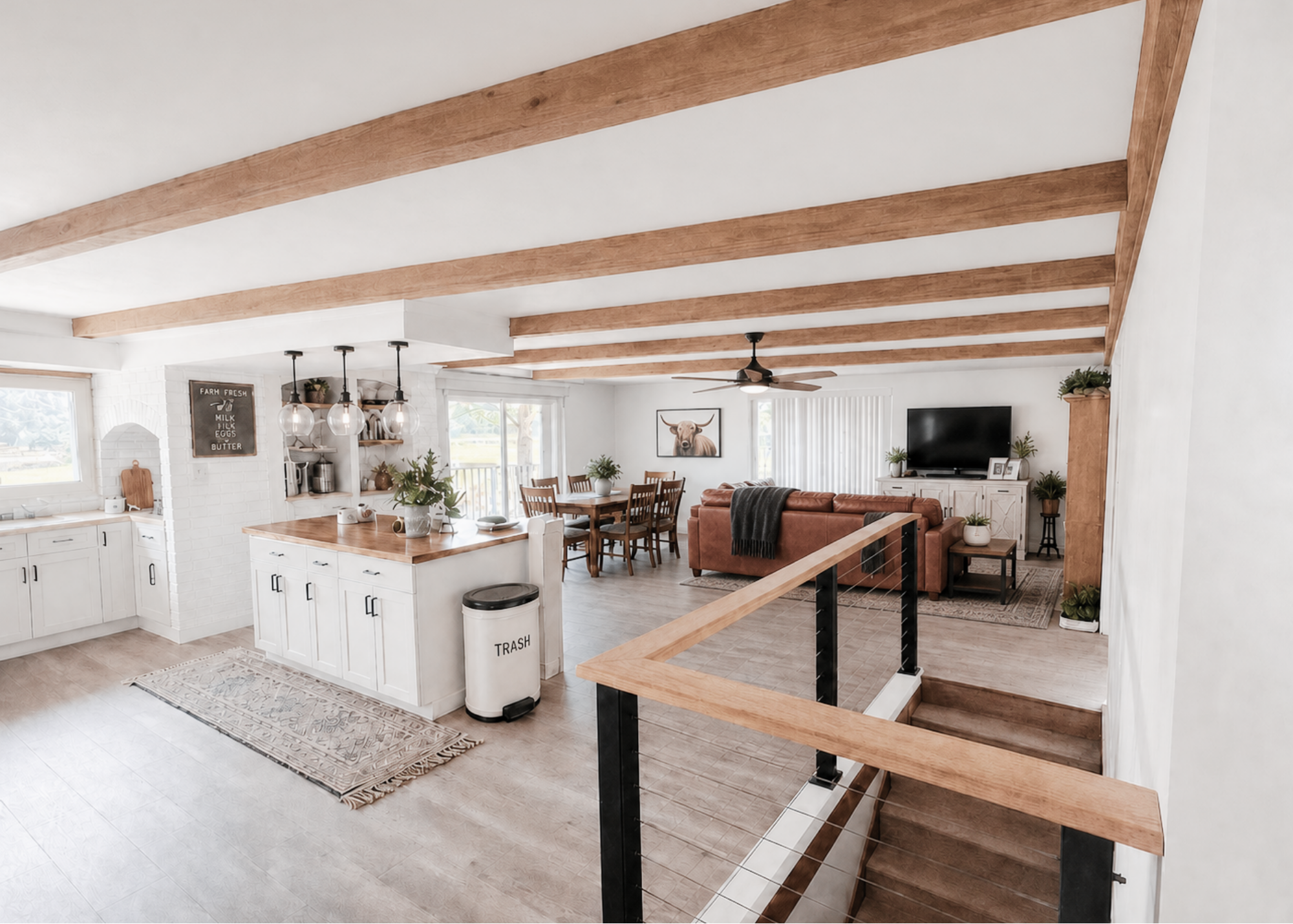 Design concept visualization of the connected kitchen, dining and living areas with wood ceiling beams, white cabinetry and coordinated furnishings